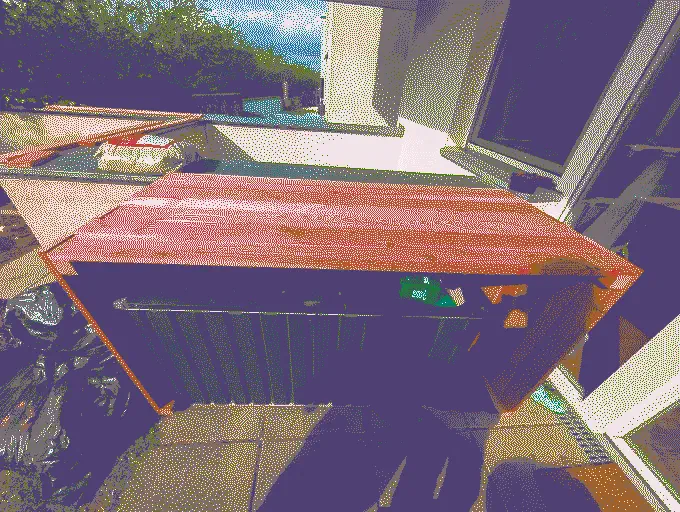 
              Three sides of the planter box are screwed together. The U-shaped construct rests over a garden toolbox
            